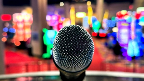 Microphone on stand in casino with colorful slot machines in the background